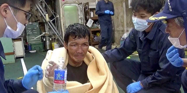 In this image made from video released by the 10th Regional Japan Coast Guard Headquarters, a rescued crew member of a Panamanian cargo ship takes a bottle of water as he speaks to Japanese Coast Guard members off the Amami Oshima, Japan Wednesday, Sept. 2, 2020. Japanese rescuers have safely plucked the crew member from the sea while searching for the cargo ship carrying more than 40 crew and thousands of cows went missing after sending a distress call off the southern Japanese island. (The 10th Regional Japan Coast Guard Headquarters via AP)