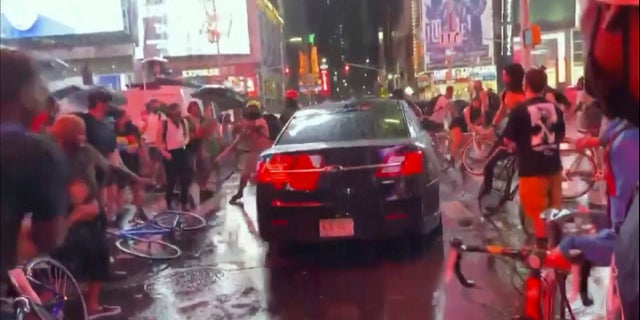 In this frame grab from a video by @datainput from the New York City Police Department Twitter account, a car moves through protesters, in New York's Times Square on Thursday. The New York Police Department says it is trying to find the car that drove through a group of Black Lives Matter protesters blocking a street in Times Square. (New York City Police Dept. via AP)
