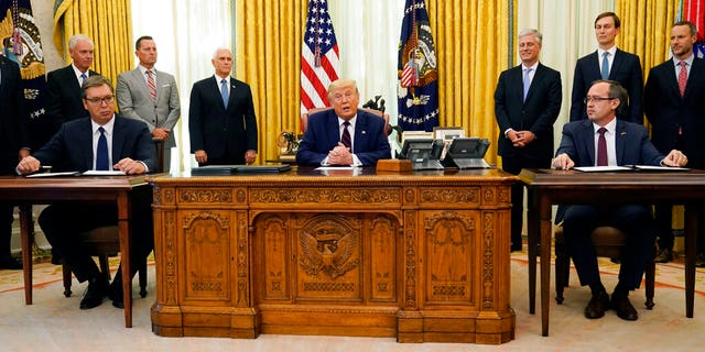 President Donald Trump participates in a signing ceremony with Serbian President Aleksandar Vucic, seated left, and Kosovar Prime Minister Avdullah Hoti, seated right, in the Oval Office of the White House, Friday, Sept. 4, 2020, in Washington. (AP Photo/Evan Vucci)