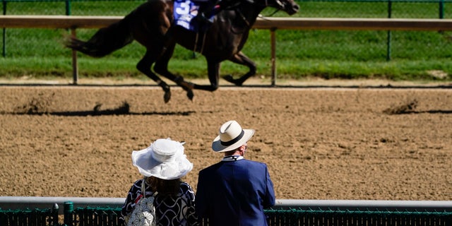 A couple watch a race before the 146th running of the Kentucky Derby at Churchill Downs, Sept. 5, in Louisville, Ky. (AP Photo/Charlie Riedel)