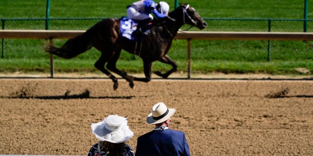 A couple watch a race before the 146th running of the Kentucky Derby at Churchill Downs, Sept. 5, in Louisville, Ky. (AP Photo/Charlie Riedel)