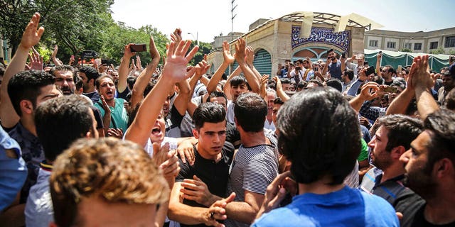 In this June 25, 2018 photo, a group of protesters chant slogans at the main gate of the Old Grand Bazaar, in Tehran, Iran. On Saturday, Sept. 5, 2020, Iran broadcast the televised confession of a wrestler facing the death penalty after a tweet from President Donald Trump criticizing the case. The case of 27-year-old Navid Afkari has drawn the attention of a social media campaign that portrays him and his brothers as victims targeted over participating in protests against Iran's Shiite theocracy in 2018. (Iranian Labor News Agency via AP)