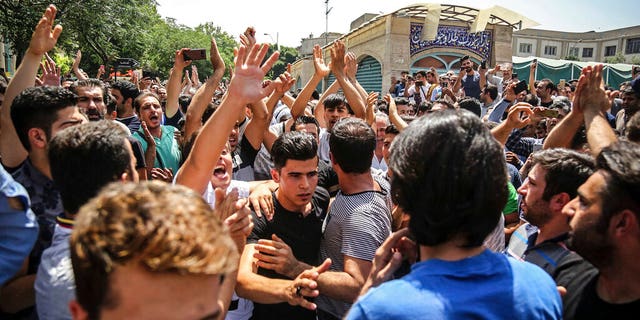 In this June 25, 2018 file photo, a group of protesters chant slogans at the main gate of the Old Grand Bazaar, in Tehran, Iran. (Iranian Labor News Agency via AP, File)