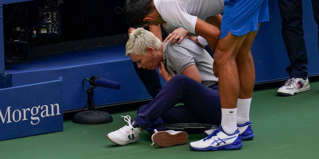Novak Djokovic checks a linesman after hitting her with a ball in reaction to losing a point during the fourth round of the US Open tennis championships on Sunday, Sept. 6, 2020, in New York. Djokovic defaulted the match. (AP Photo/Seth Wenig)
