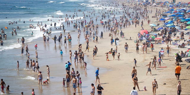 People are seen at the beach during a heat wave, Sunday, Sept. 6, 2020, in Huntington Beach, Calif. (AP Photo/Christian Monterrosa)