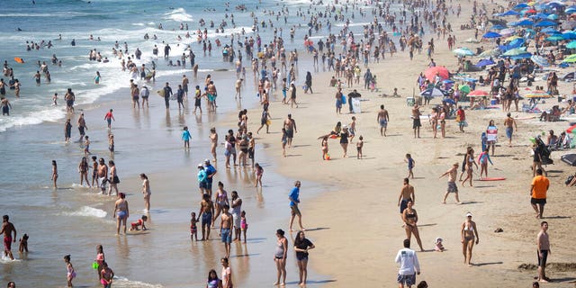 People are seen at the beach during a heat wave, Sunday, Sept. 6, 2020, in Huntington Beach, Calif. (AP Photo/Christian Monterrosa)