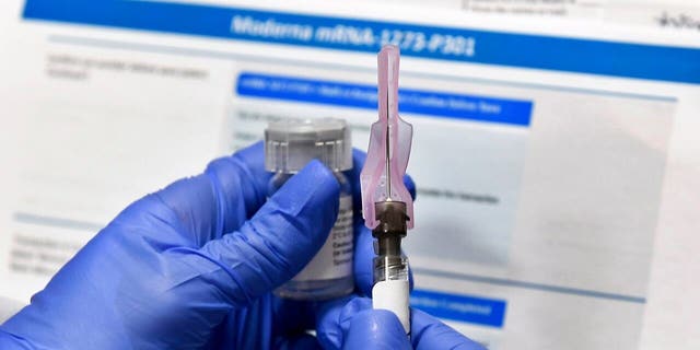 A nurse prepares a shot as a study of a possible COVID-19 vaccine, developed by the National Institutes of Health and Moderna Inc., gets underway in Binghamton, N.Y., in July.  (AP Photo/Hans Pennink)