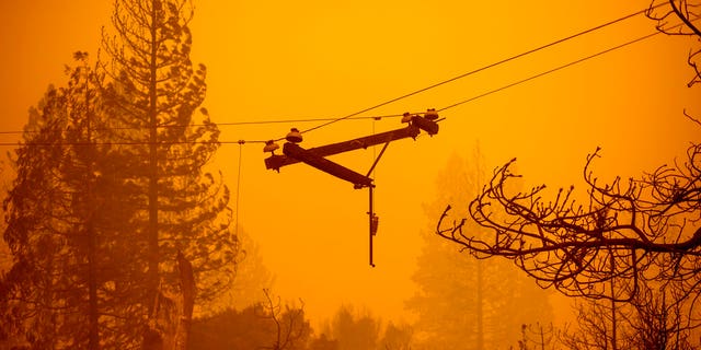 A power line dangles along Auberry Road following the Creek Fire on Tuesday, Sept. 8, 2020, in Fresno County, Calif. (AP Photo/Noah Berger)