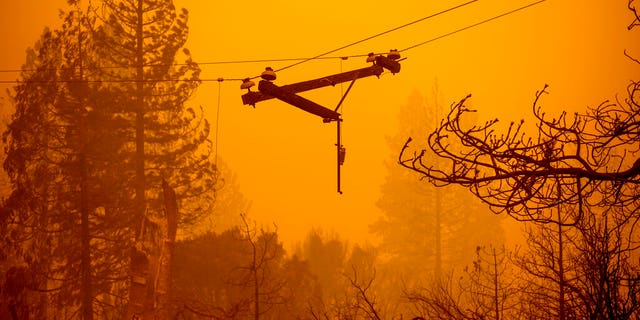 A power line dangles along Auberry Road following the Creek Fire on Tuesday, Sept. 8, 2020, in Fresno County, Calif. (AP Photo/Noah Berger)