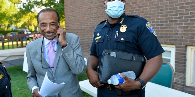 Rochester Police Chief La'Ron Singletary, right, stands with Reverend Lewis W. Stewart, left, of the United Christian Leadership Ministry before a community meeting in Rochester, N.Y.. Rochester Mayor Lovely Warren said Tuesday, Sept. 8, 2020, that the city’s police chief is among those retiring, along with other senior commanders, amid criticism of the city’s handling of the suffocation death of Daniel Prude. (AP Photo/Adrian Kraus)