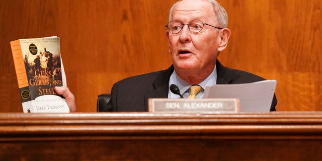 Senate Health, Education, Labor, and Pensions Committee Chairman Lamar Alexander, R-Tenn., holds up a copy of "Guns, Germs, and Steel" by Jared Diamond.