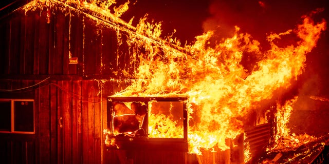 Flames shoot from a home as the Bear Fire burns through the Berry Creek area of Butte County, Calif., on Wednesday, Sept. 9, 2020.