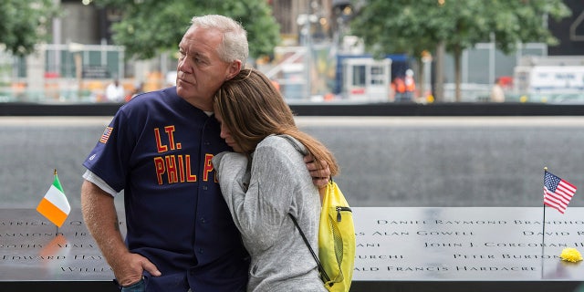 In this Sept. 11, 2015, file photo, victims' family members look on during a ceremony at the World Trade Center site in New York. The terror attacks' 19th anniversary will be marked Friday, Sept. 11, 2020, by dueling ceremonies at the Sept. 11 memorial plaza and a corner nearby in New York. (AP Photo/Bryan R. Smith, File)