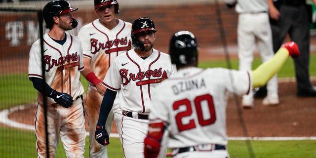 Atlanta Braves' Dansby Swanson, left, Ender Inciarte, center, and Austin Riley return to the dugout after scoring in a double by Ronald Acuna Jr. during the sixth inning of a baseball game against the Miami Marlins on on Wednesday, Sept. 9, 2020, in Atlanta. (Associated Press)