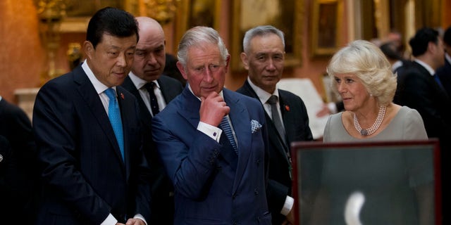 Britain's Prince Charles, center, his wife, Camilla, Duchess of Cornwall, and Chinese ambassador to the U.K. Liu Xiaoming view a display of Chinese items from the Royal Collection at Buckingham Palace in London on Oct. 20, 2015.