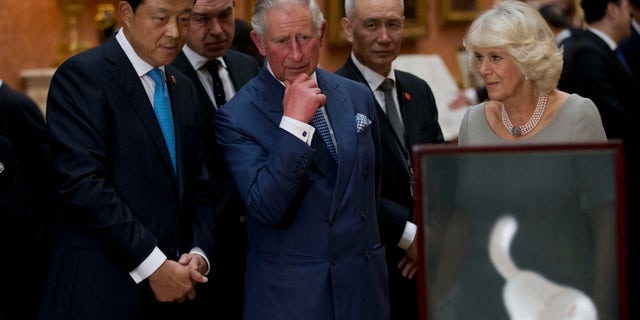 Britain's Prince Charles, center, his wife, Camilla, Duchess of Cornwall, and Chinese ambassador to the U.K. Liu Xiaoming view a display of Chinese items from the Royal Collection at Buckingham Palace in London on Oct. 20, 2015.