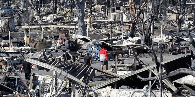 Men walk through the fire-ravaged Coleman Creek Estates mobile home park in Phoenix, Ore., on Sept. 9. The Almeda Fire that burned through the towns of Phoenix and Talent in southern Oregon destroyed approximately 600 homes, according to the Federal Emergency Management Agency. (Scott Stoddard/Grants Pass Daily Courier via AP)