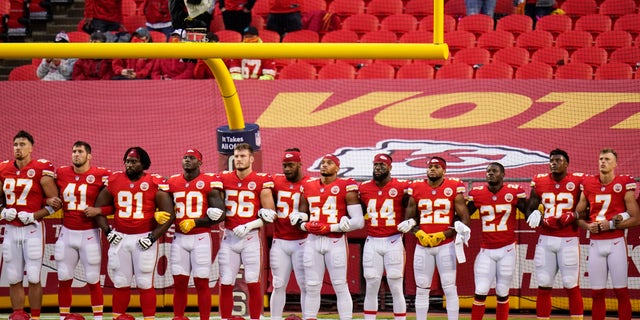 Kansas City Chiefs players stand for a presentation on social justice before an NFL football game against the Houston Texans Thursday, Sept. 10, 2020, in Kansas City, Mo. (AP Photo/Charlie Riedel)