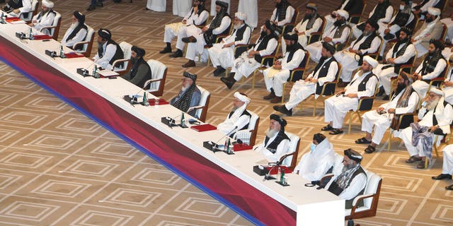 Taliban negotiator Abbas Stanikzai, fifth right, with his delegation attend the opening session of the peace talks between the Afghan government and the Taliban in Doha, Qatar, Saturday, Sept. 12, 2020. (AP Photo/Hussein Sayed)