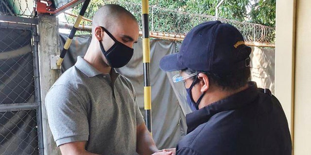  In this photo provided by the Philippines' Bureau of Immigration, U.S. Marine Lance Cpl. Joseph Scott Pemberton has handcuffs placed before leaving Camp Aguinaldo on his way to the airport in Quezon city, Philippines, Sunday, Sept. 13, 2020. (Bureau of Immigration via AP)