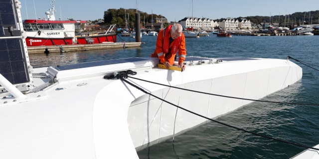 Keith Ivory, a safety specialist, checks the Mayflower Autonomous Ship in Plymouth, England, on Monday, Sept. 14. The vessel aims to cross the Atlantic to Plymouth, Massachusetts, in April 2021. (AP Photo/Alastair Grant)