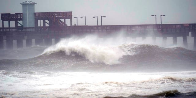 Waves crash near a pier, at Gulf State Park, Sept. 15, in Gulf Shores, Ala. Hurricane Sally is crawling toward the northern Gulf Coast at just 2 mph, a pace that's enabling the storm to gather huge amounts of water to eventually dump on land. (AP Photo/Gerald Herbrt)