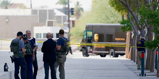 Federal law enforcement personnel stand outside the Sandra Day O'Connor Federal Courthouse Sept. 15, in Phoenix. A drive-by shooting wounded a federal court security officer Tuesday outside the courthouse in downtown Phoenix, authorities said. The officer was taken to a hospital and is expected to recover, according to city police and the FBI, which is investigating. (AP Photo/Ross D. Franklin)