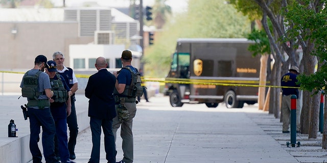 Federal law enforcement personnel stand outside the Sandra Day O'Connor Federal Courthouse Sept. 15, in Phoenix. A drive-by shooting wounded a federal court security officer Tuesday outside the courthouse in downtown Phoenix, authorities said. The officer was taken to a hospital and is expected to recover, according to city police and the FBI, which is investigating. (AP Photo/Ross D. Franklin)