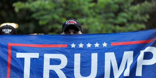 A person holds up a Trump flag at Independence Mall to support U.S. President Donald Trump as he visits the National Constitution Center to participate in the ABC News town hall.