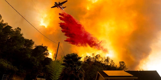 In this Aug. 18 photo, an air tanker drops retardant as the LNU Lightning Complex fires tear through the Spanish Flat community in unincorporated Napa County, Calif. Two unusual weather phenomena combined to create some of the most destructive wildfires the West Coast states have seen in modern times. (AP Photo/Noah Berger, File)