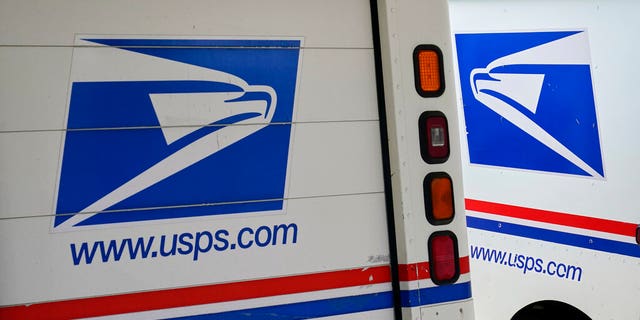 FILE: Mail delivery vehicles are parked outside a post office in Boys Town, Neb.