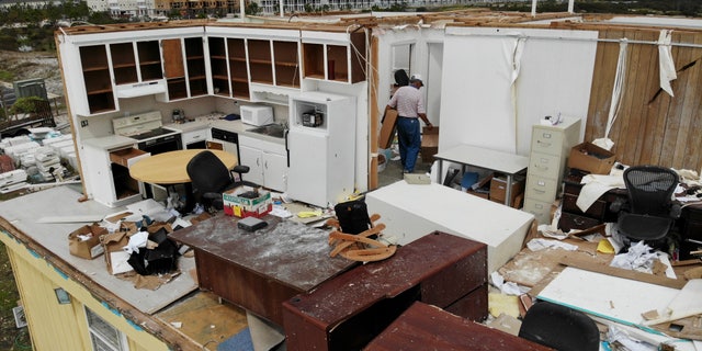 Joe Mirable surveys the damage to his business after Hurricane Sally moved through the area, Thursday, Sept. 17, 2020, in Perdido Key, Fla. Rivers swollen by Hurricane Sally's rains threatened more misery for parts of the Florida Panhandle and south Alabama on Thursday, as the storm's remnants continued to dump heavy rains inland that spread the threat of flooding to Georgia and the Carolinas. (AP Photo/Angie Wang)