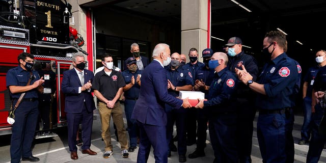 Democratic presidential candidate former Vice President Joe Biden greets firefighters as he makes a stop in Duluth, Minn., Friday, Sept. 18, 2020. Second from left is the Mayor of Duluth Emily Larson. (AP Photo/Carolyn Kaster)