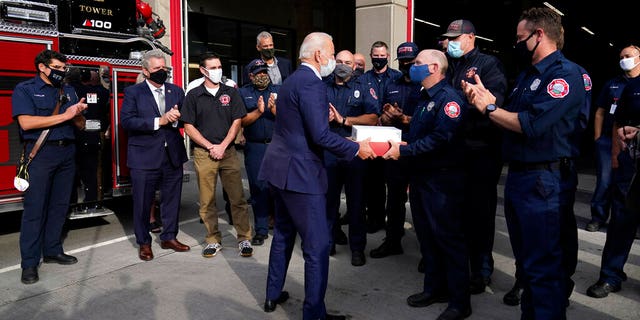 Democratic presidential candidate former Vice President Joe Biden greets firefighters as he makes a stop in Duluth, Minn., Friday, Sept. 18, 2020. Second from left is the Mayor of Duluth Emily Larson. (AP Photo/Carolyn Kaster)