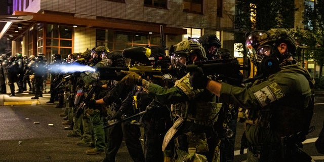 Federal police try to take control of the streets during protests, Friday, Sept. 18, 2020, in Portland, Ore. Oregon Gov. Kate Brown declared a state of emergency Friday in anticipation of a rally planned in Portland over the weekend that could potentially turn violent. (AP Photo/Paula Bronstein)