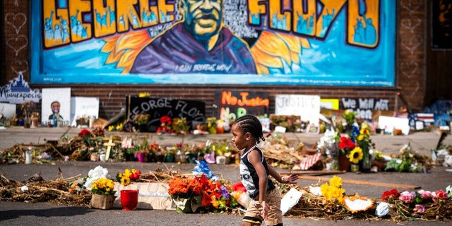 Carter Sims, 3, of Pine Island ran past a mural at the George Floyd memorial outside Cup Foods. LEILA NAVIDI • leila.navidi@startribune.com