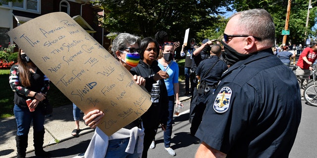 Louisville Metro police officers attempt to get protesters out of the street during a rally outside the house of Senate Majority Leader Mitch McConnell, R-Ky., in Louisville, Ky., Saturday, Sept. 19, 2020.(AP Photo/Timothy D. Easley)