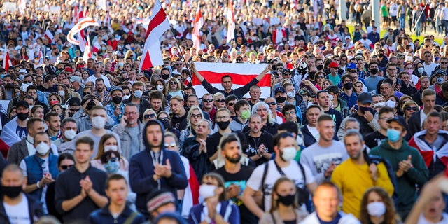 Protesters with old Belarusian national flags march during an opposition rally to protest the official presidential election results in Minsk, Belarus, Sunday, Sept. 20, 2020. Protests calling for the authoritarian president's resignation broke out after an Aug. 9 election that officials say gave him a sixth term in office and that opponents say was rigged. (AP Photo/TUT.by)