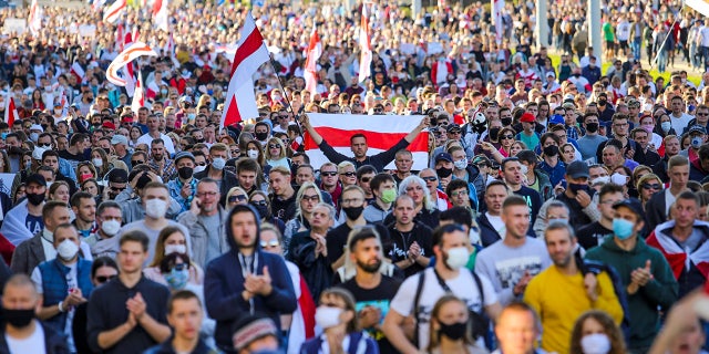 Protesters with old Belarusian national flags march during an opposition rally to protest the official presidential election results in Minsk, Belarus, Sunday, Sept. 20, 2020. Protests calling for the authoritarian president's resignation broke out after an Aug. 9 election that officials say gave him a sixth term in office and that opponents say was rigged. (AP Photo/TUT.by)