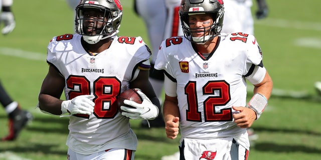 Tampa Bay Buccaneers running back Leonard Fournette (28) runs off the field with quarterback Tom Brady (12) after Fournette ran 46-yards for a score against the Carolina Panthers during the second half of an NFL football game Sunday, Sept. 20, 2020, in Tampa, Fla. (AP Photo/Mark LoMoglio)
