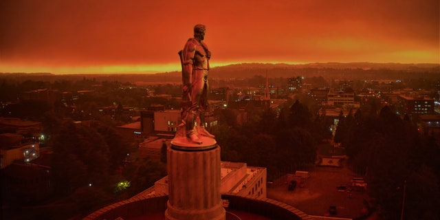 This drone photo provided by Michael Mann shows the Oregon Capitol building, with its "Oregon Pioneer" bronze sculpture atop the dome, as smoke and ash from nearby wildfires cloud skies in Salem, Ore., on Sept. 8, 2020.  (Michael Mann via AP)