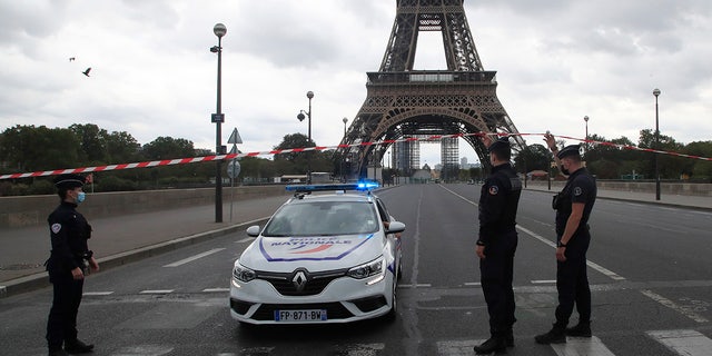 French police officers secure the bridge leading to the Eiffel Tower, Wednesday, Sept. 23, 2020, in Paris. Paris police have blockaded the area around the Eiffel Tower after a phone-in bomb threat. (AP Photo/Michel Euler)