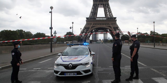 French police officers secure the bridge leading to the Eiffel Tower, Wednesday, Sept. 23, 2020, in Paris. Paris police have blockaded the area around the Eiffel Tower after a phone-in bomb threat. (AP Photo/Michel Euler)