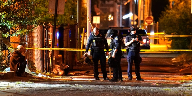 Police survey an area after a police officer was shot, Wednesday, Sept. 23, 2020, in Louisville, Ky. (Associated Press)
