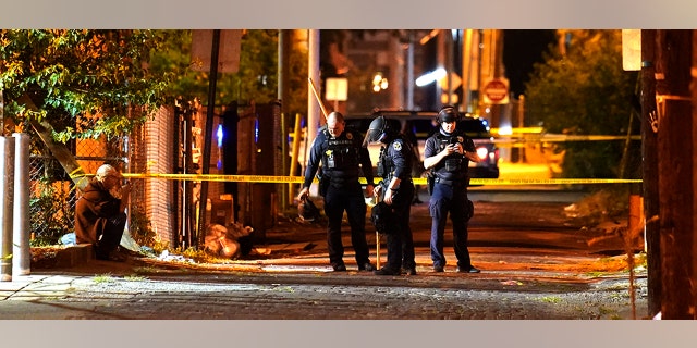 Police survey an area after a police officer was shot, Wednesday, Sept. 23, 2020, in Louisville, Ky. (Associated Press)