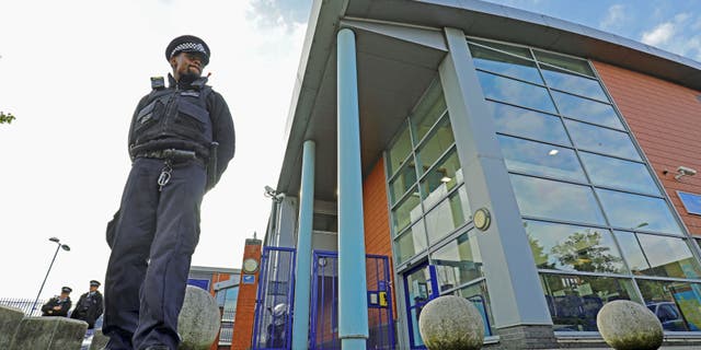 A police officer stands outside Croydon Custody Centre where a police officer was shot in the early hours of Friday, Sept. 25, 2020, in Croydon, England. (Associated Press)