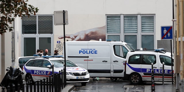 Police car park outside a building after four people have been wounded in a knife attack near the former offices of satirical newspaper Charlie Hebdo on Sept. 25, 2020 in Paris. (AP Photo/Thibault Camus)