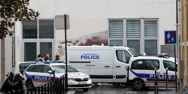 Police car park outside a building after four people have been wounded in a knife attack near the former offices of satirical newspaper Charlie Hebdo on Sept. 25, 2020 in Paris. (AP Photo/Thibault Camus)