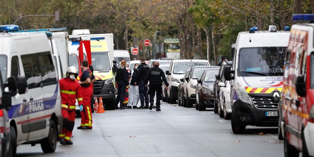 French police officers and rescue workers gather after four people have been wounded in a knife attack near the former offices of satirical newspaper Charlie Hebdo, Friday Sept. 25, 2020 in Paris. (AP Photo/Thibault Camus)