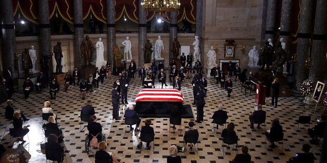 A U.S. Capitol Police honor guard surrounds the flag-draped casket of Justice Ruth Bader Ginsburg as lies in state in Statuary Hall of the U.S. Capitol, Friday, Sept. 25, 2020, in Washington. (Olivier Douliery/Pool via AP)